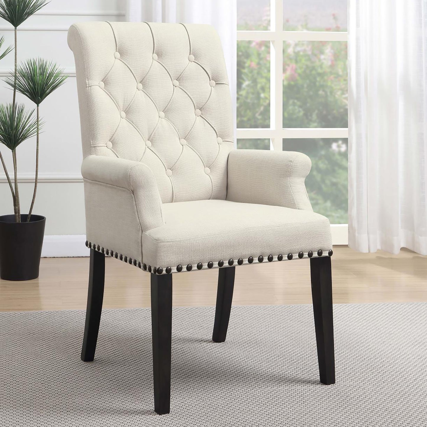 Cream tufted upholstered accent chair with dark wood legs and nailhead trim