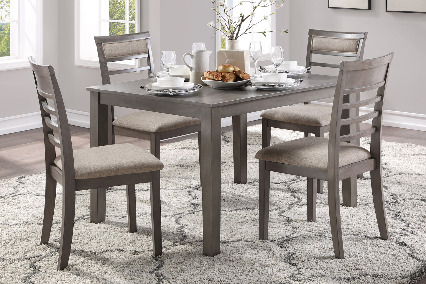 Gray wood dining set with upholstered chairs and place settings