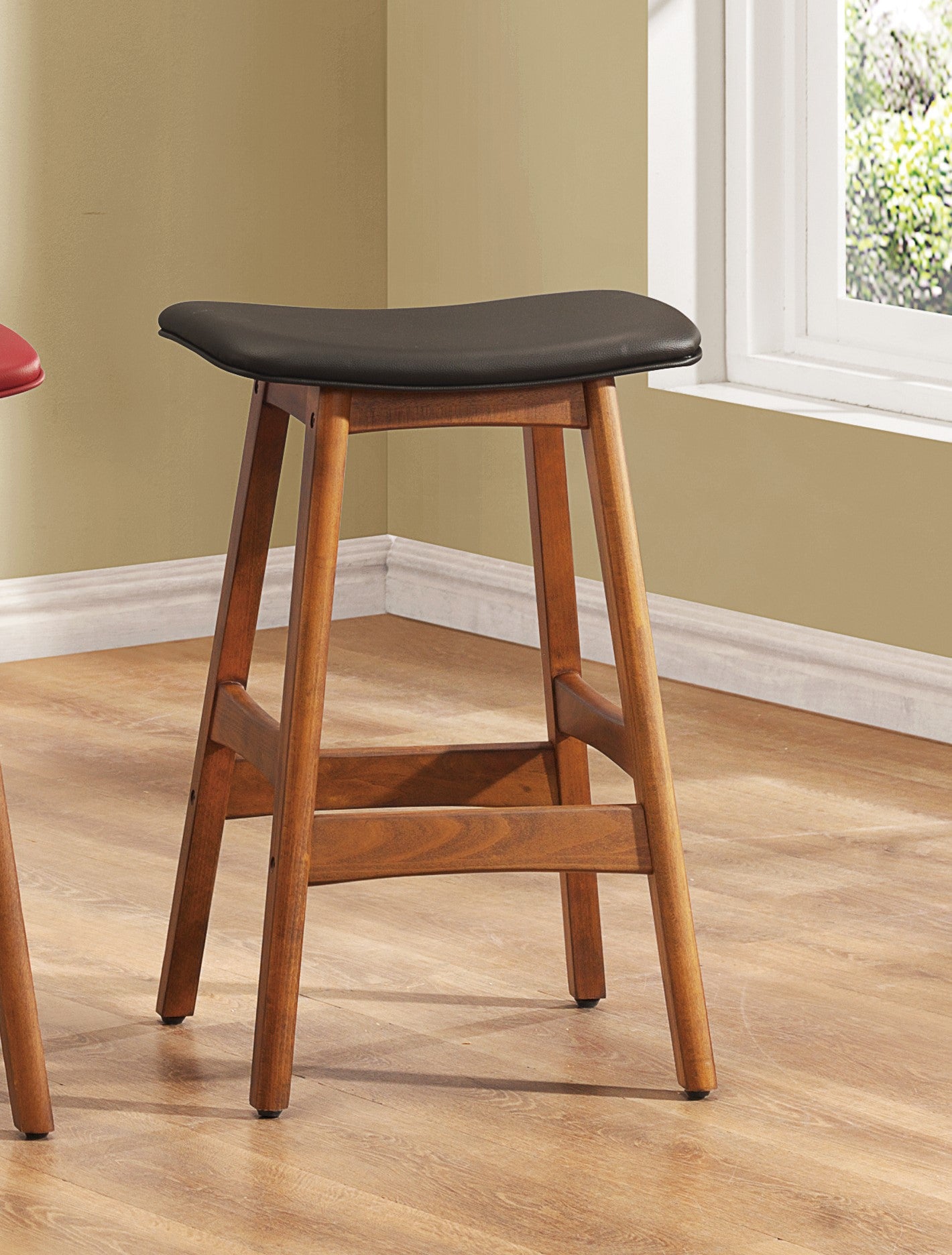 Black leather saddle stool with warm walnut wood frame perfect for kitchen counters