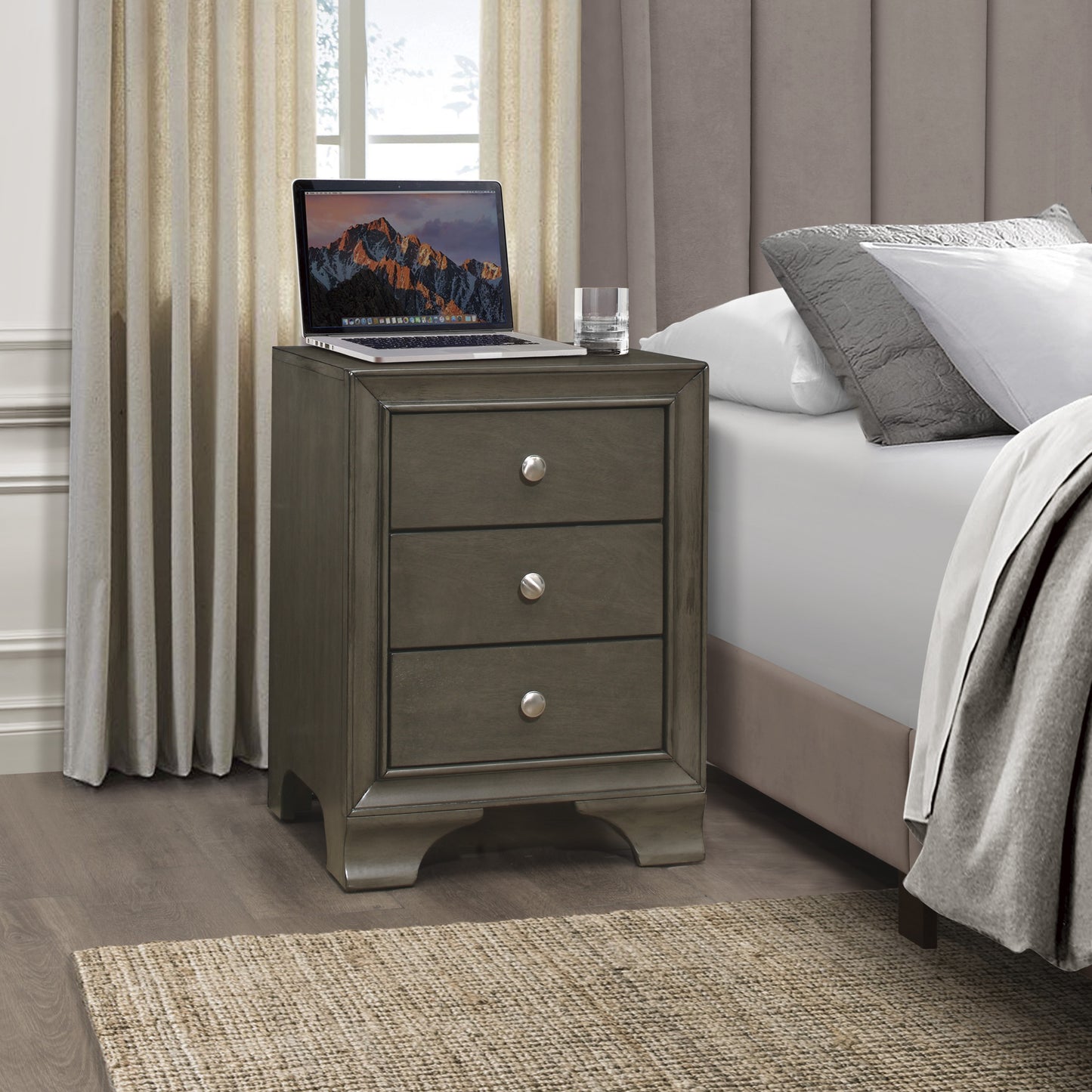 Grey wooden threedrawer nightstand with silver knobs on wooden floor