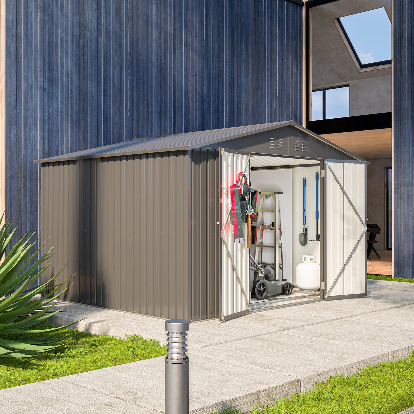 Gray metal storage shed with tools and lawnmower inside