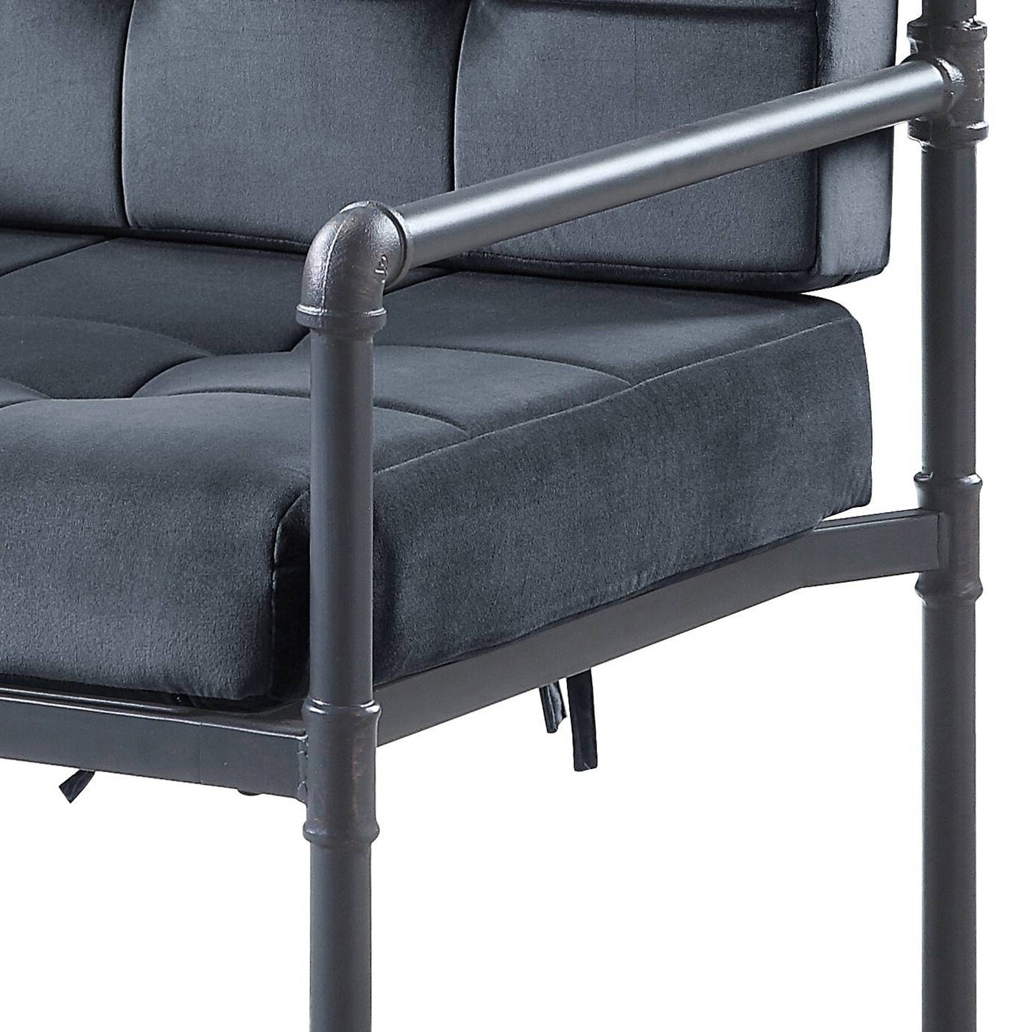 Dark gray tufted upholstered sofa with a pipeframe industrial design