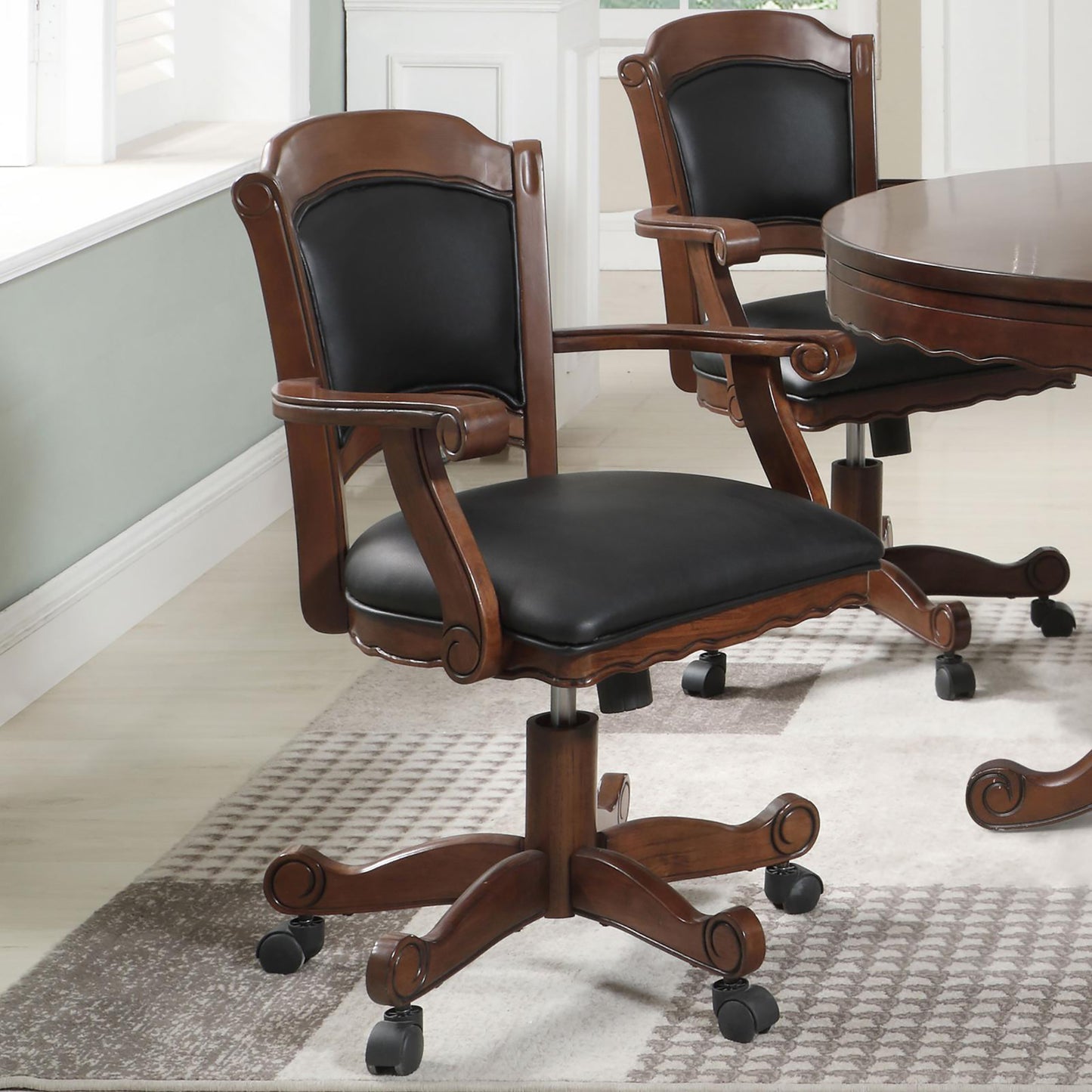 Ornate wooden desk chair with black leather seat and back on casters