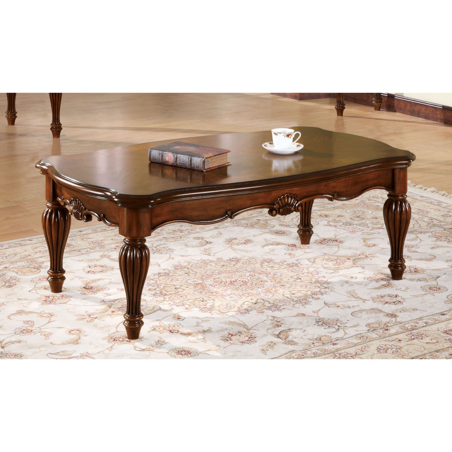 Ornate dark wood coffee table with carved legs and scalloped edges