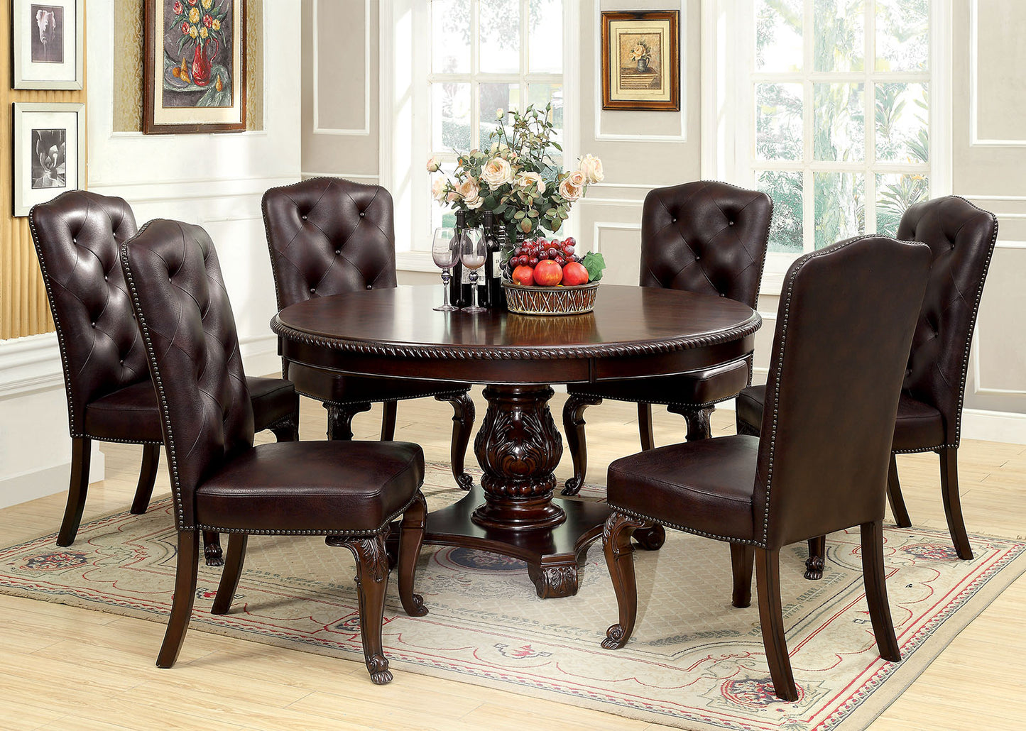 Dark brown tufted leather dining chairs with nailhead trim surround a round mahogany dining table