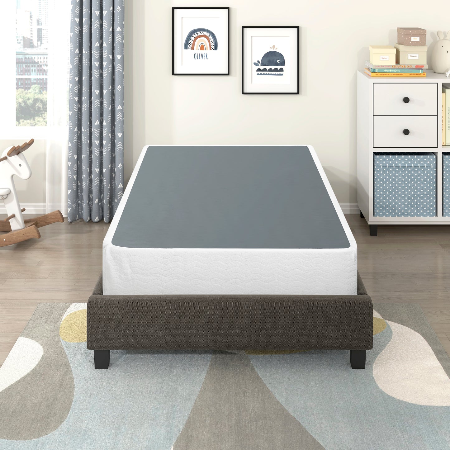 Dark gray upholstered bed frame with a white mattress and gray platform for a bedroom