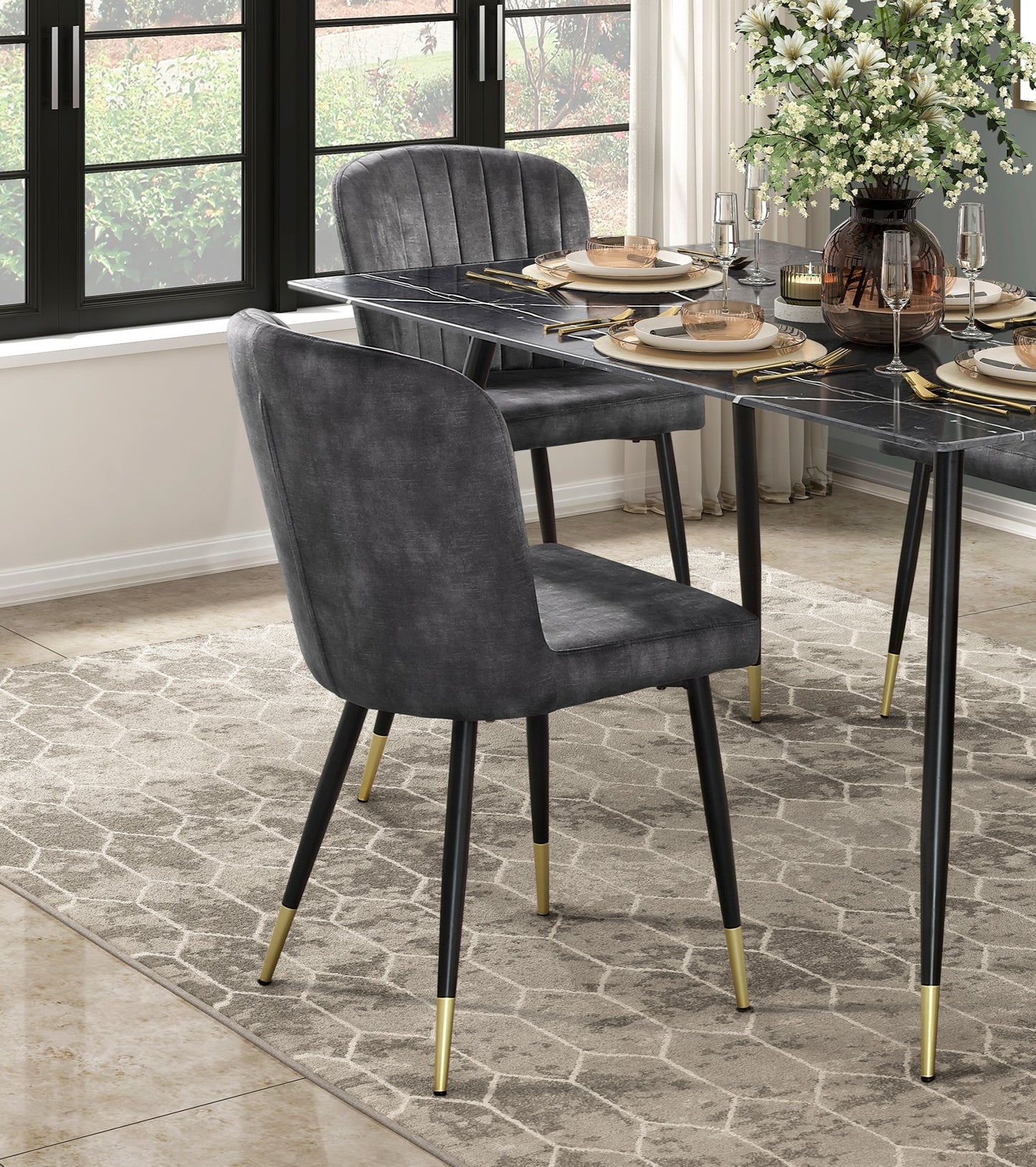 Dark gray velvet dining chair with plush channeling and goldcapped legs