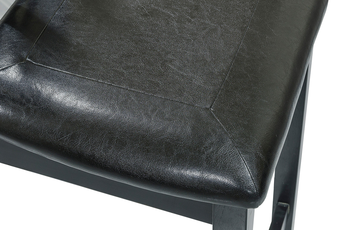 Closeup of a textured black faux leather chair seat showcasing intricate stitching and smooth finish