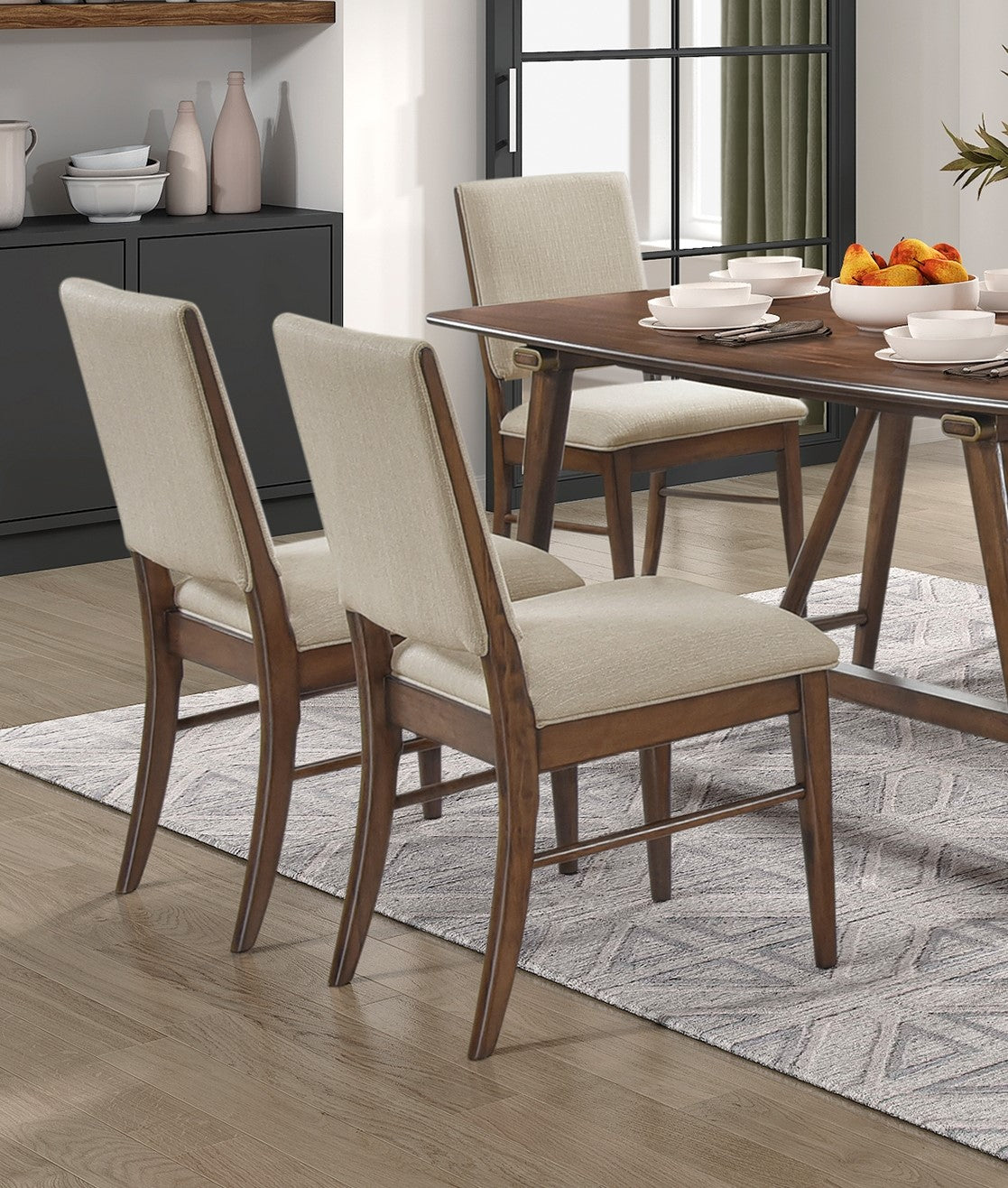 Two upholstered dining chairs with natural linen seats and warm wood frames offer comfortable seating
