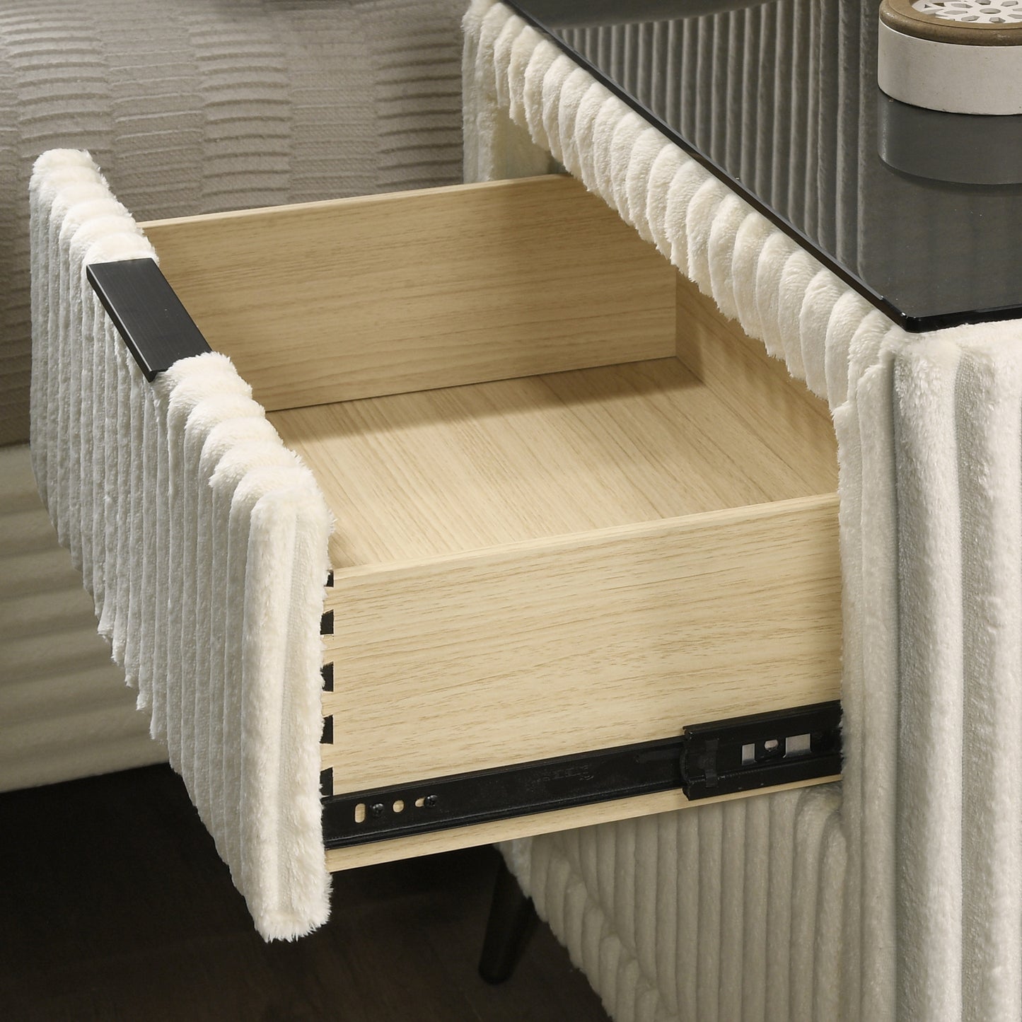 Open drawer of a cream boucle nightstand with wooden interior