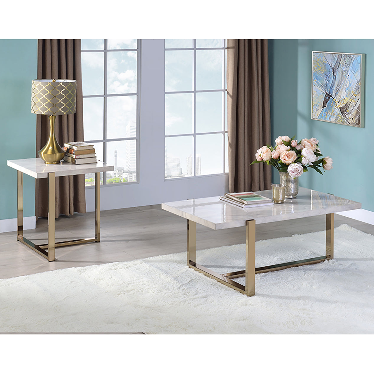 Rectangular marble coffee table with gold metal legs holding a vase of pink peonies and notebooks