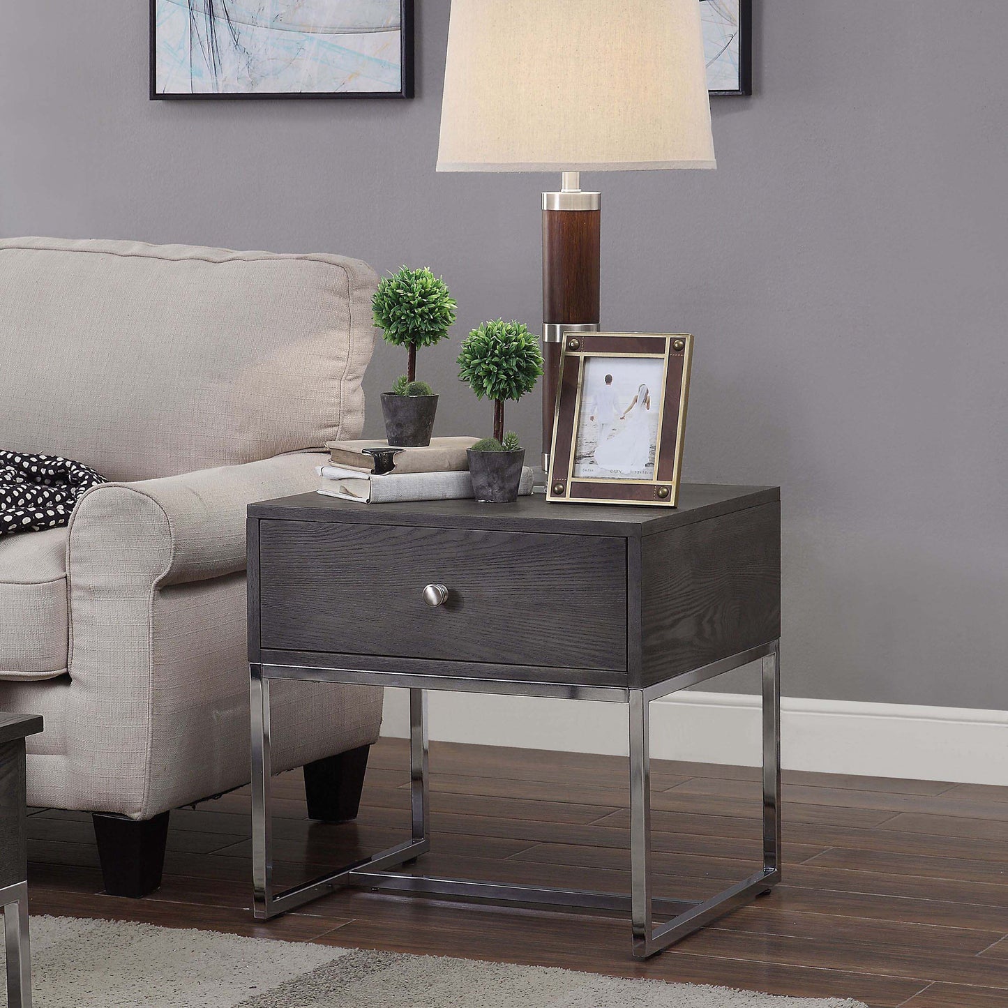 Dark gray wood and chrome end table with one drawer and decorative plant