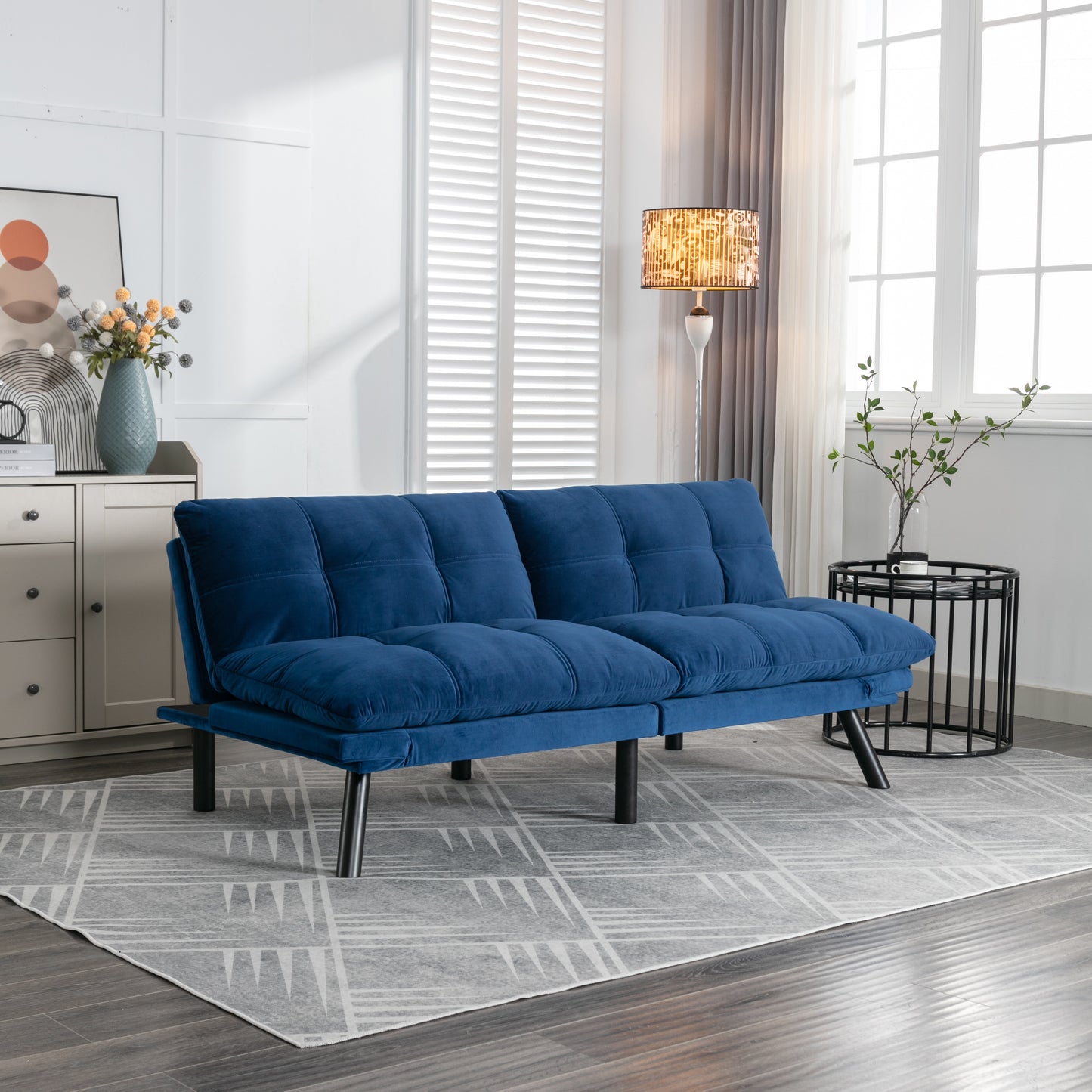 Deep blue velvet futon sofa with plush cushions and black metal legs