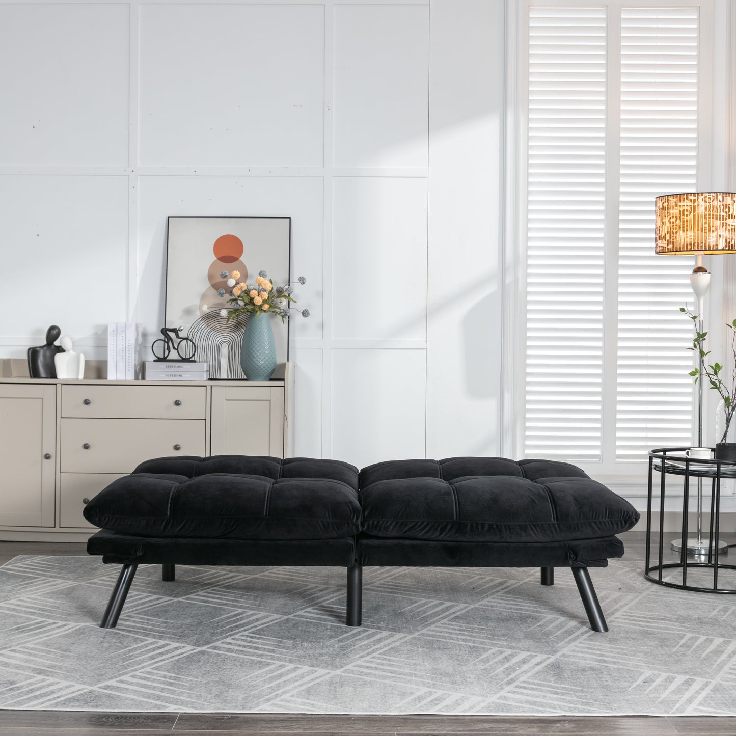 Tufted black velvet sofa bed with plush cushions and modern black legs