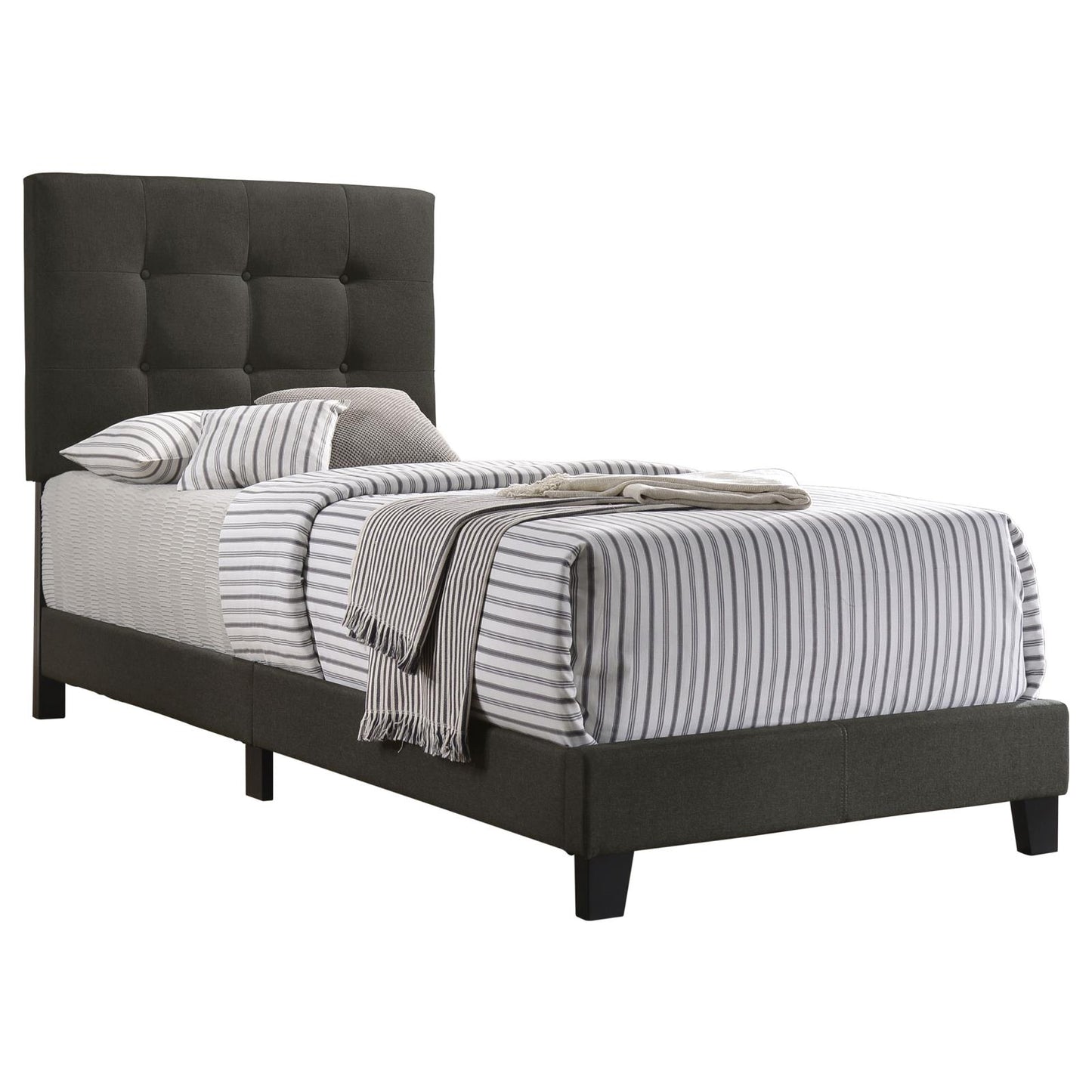 Dark gray tufted upholstered twin bed frame with striped bedding