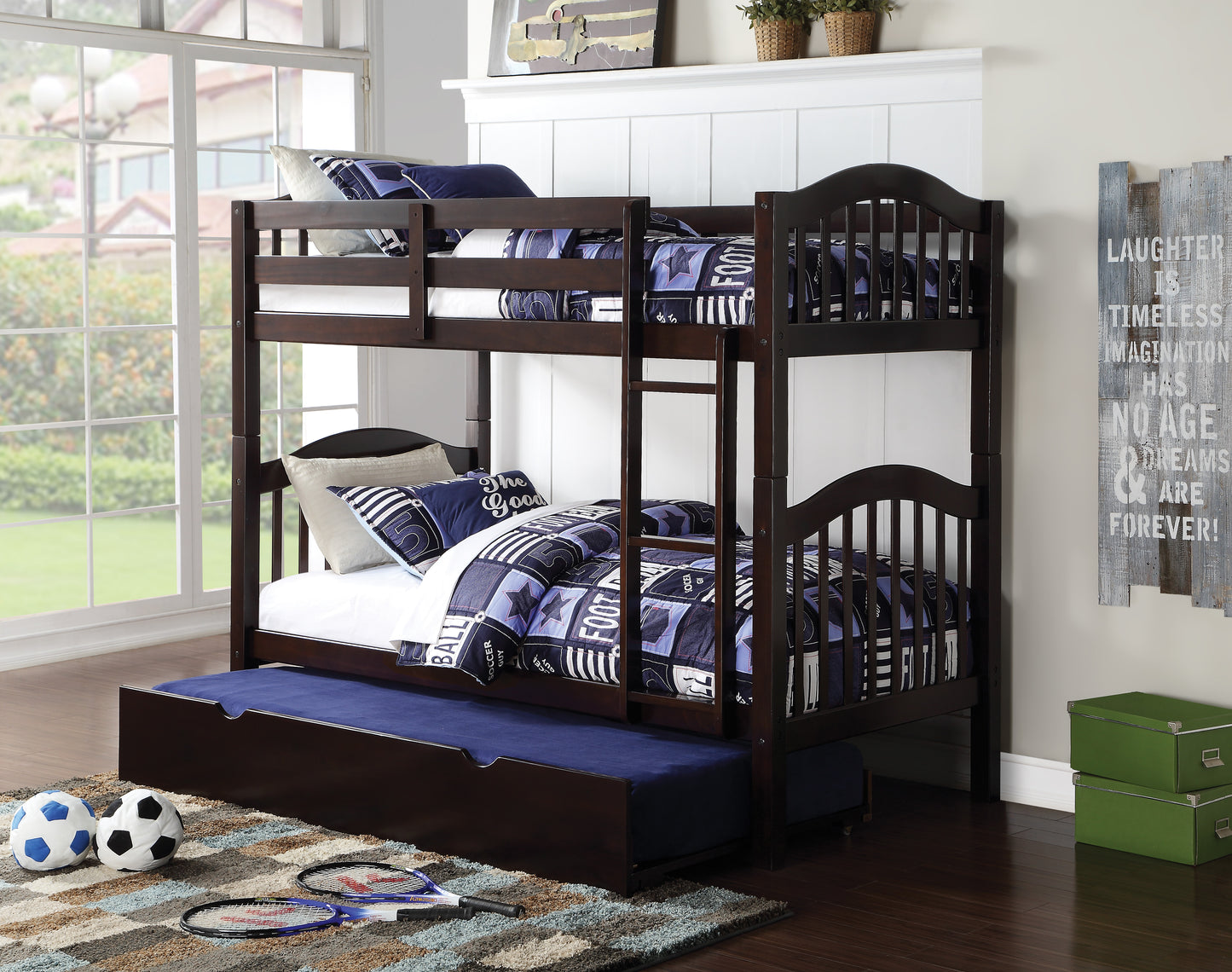 Dark brown wooden bunk bed with soccerthemed bedding and a pullout trundle