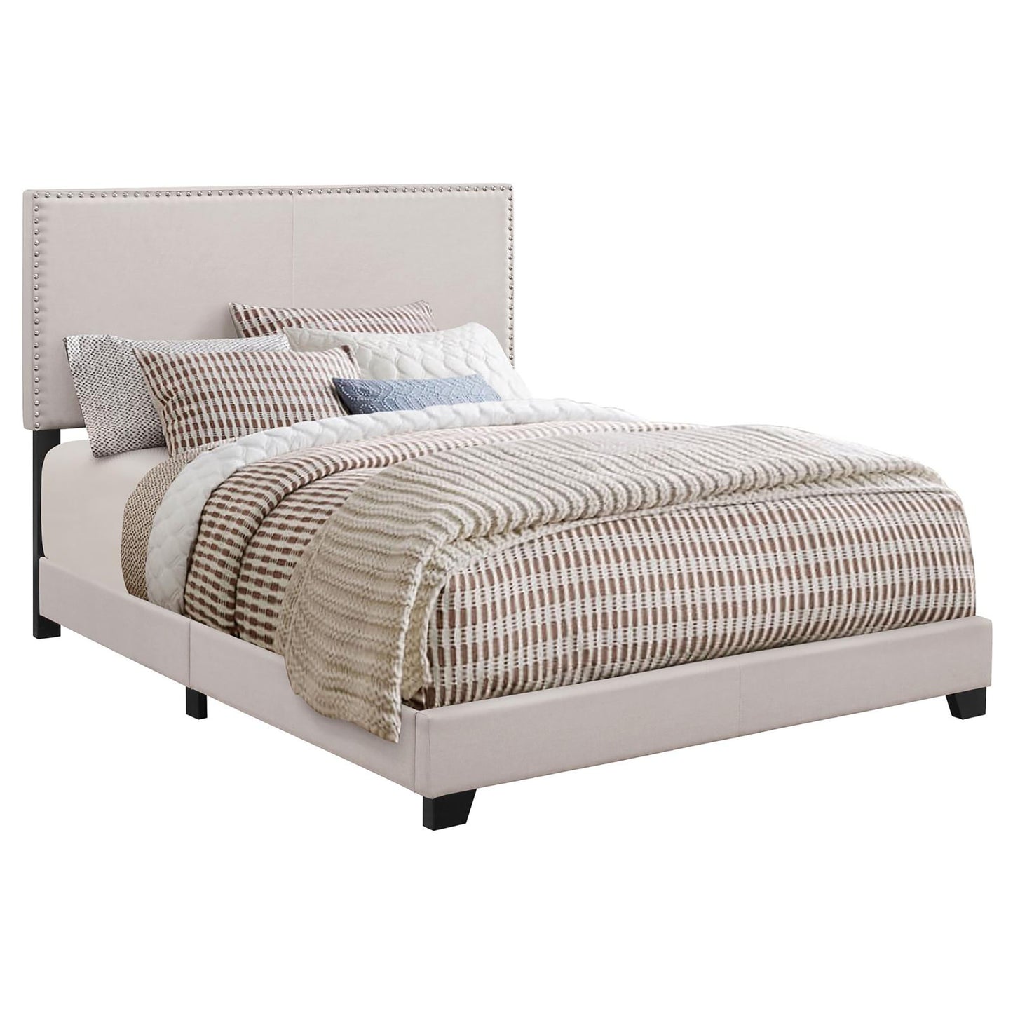 Tufted beige upholstered bed frame with decorative nailhead trim and striped bedding