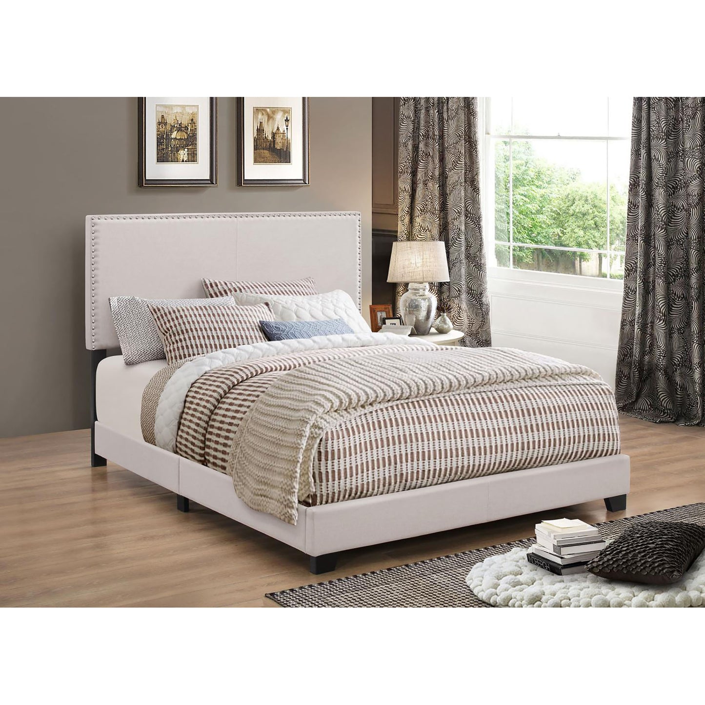 Upholstered queen bed frame in cream fabric with studded headboard
