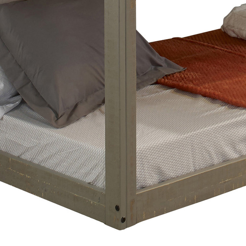 Rustic grey wood canopy bed frame with textured white mattress and charcoal pillows