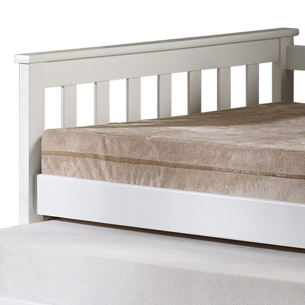 White wooden bed frame with a tan mattress and pullout bed