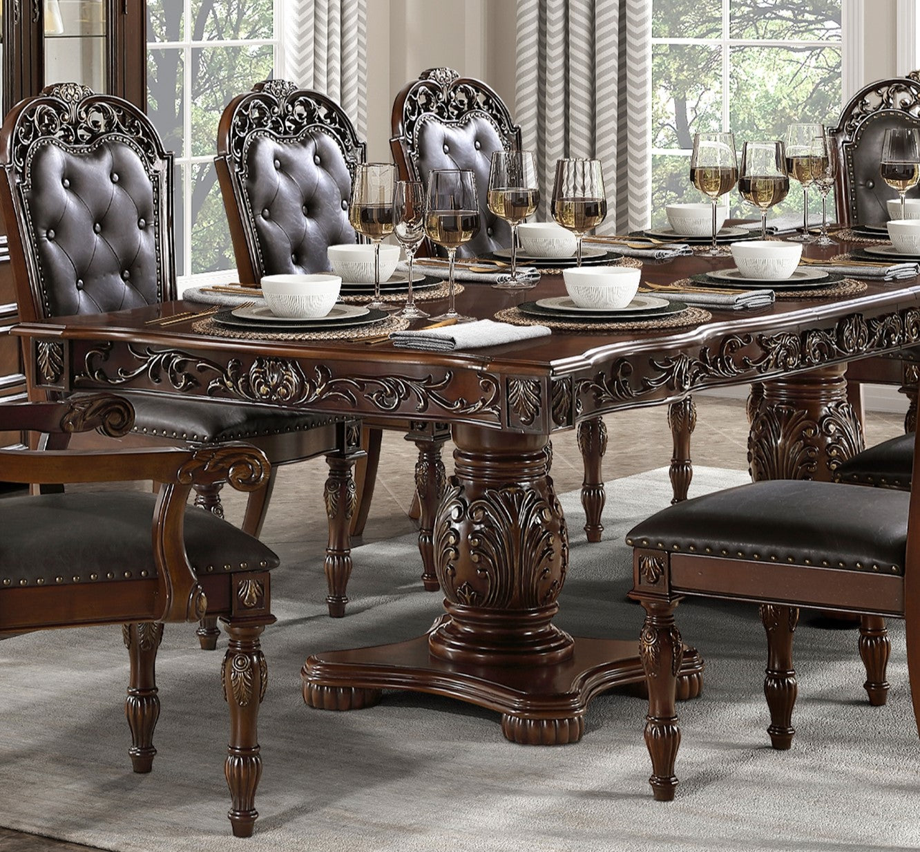 Ornate dark wood dining table with tufted leather chairs and formal place settings
