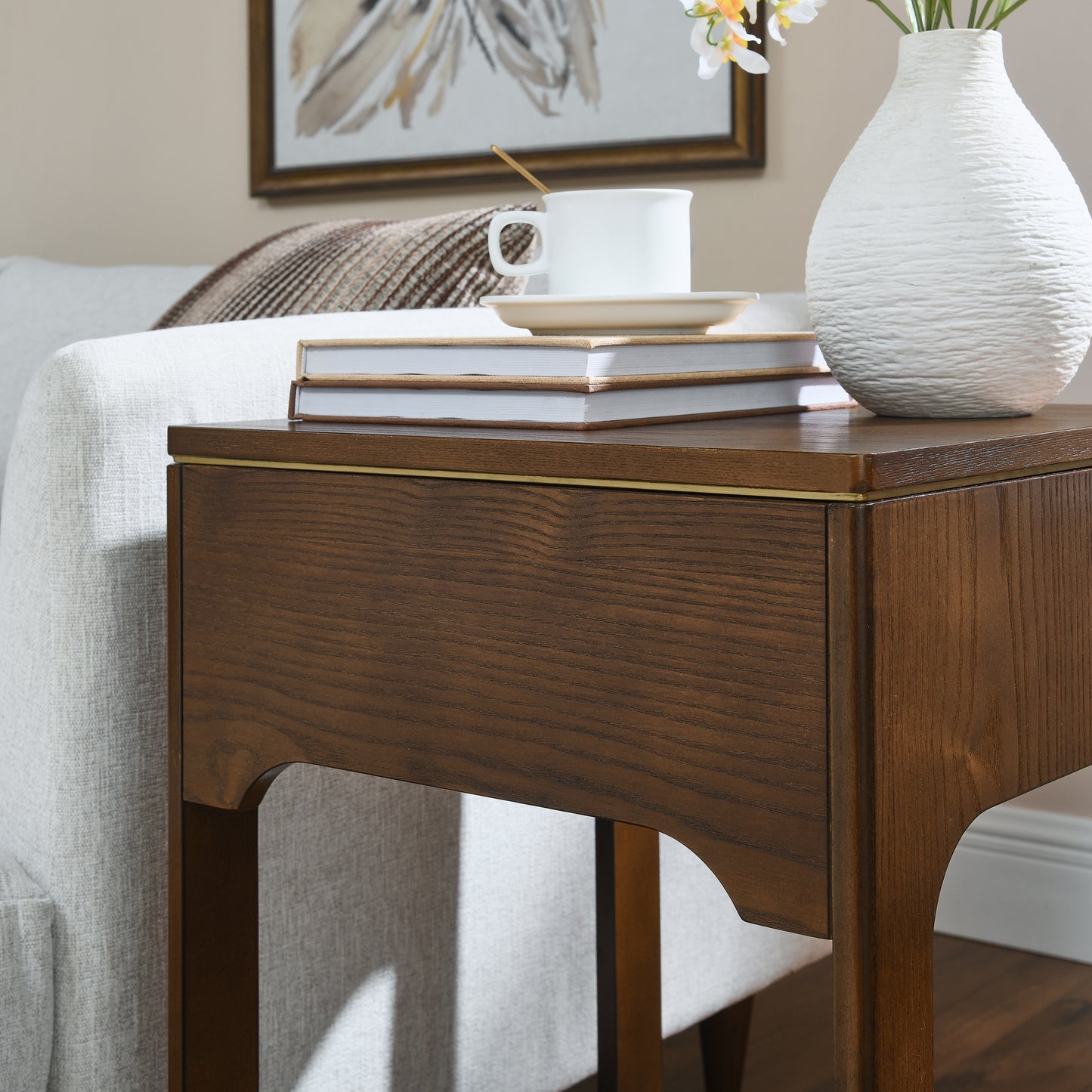 Dark oak wood end table with brass inlay detail and textured white vase