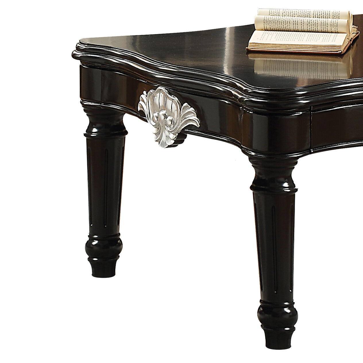 Black ornate carved table with silver accent and open book