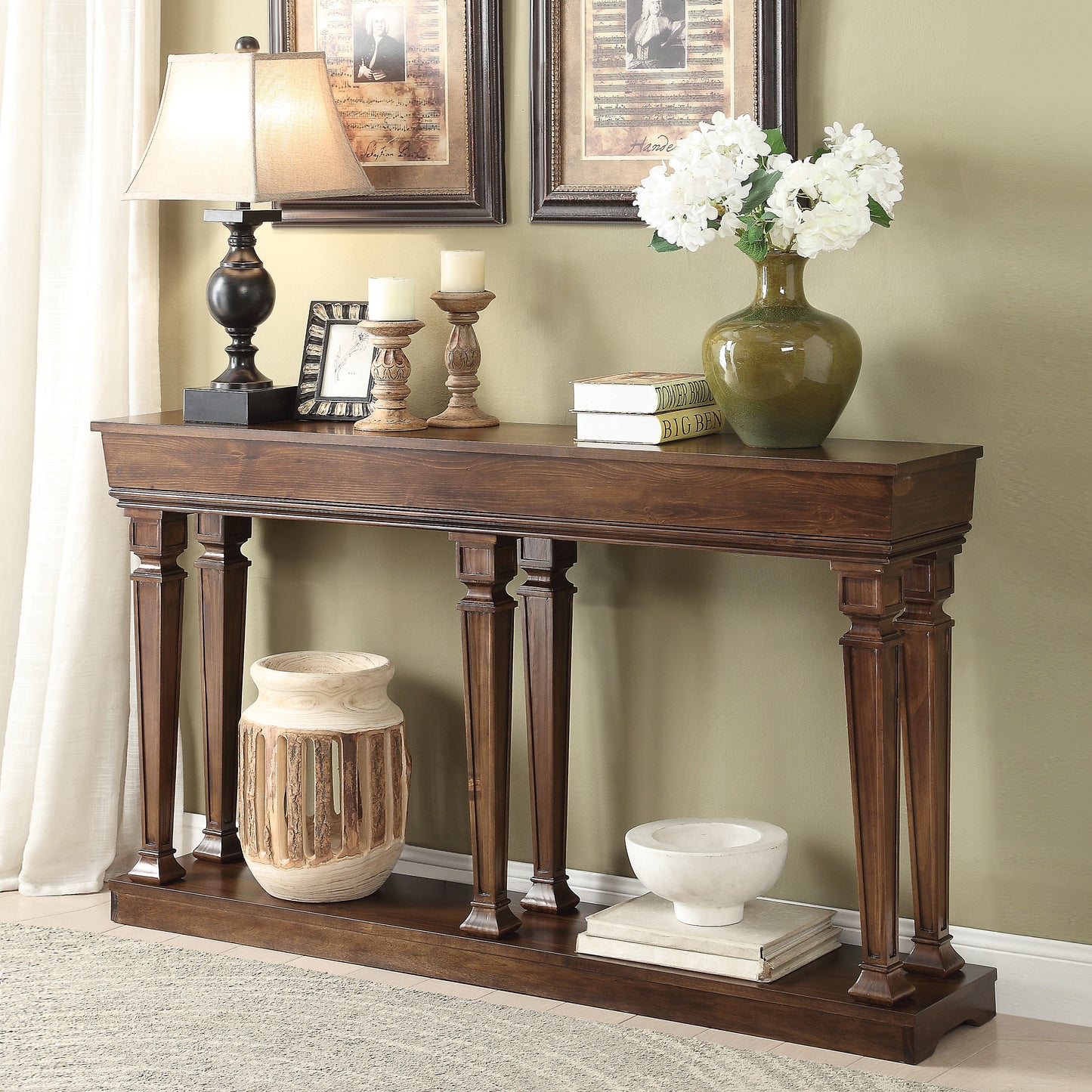 Dark wood console table with carved legs and decorative items like a lamp and vase