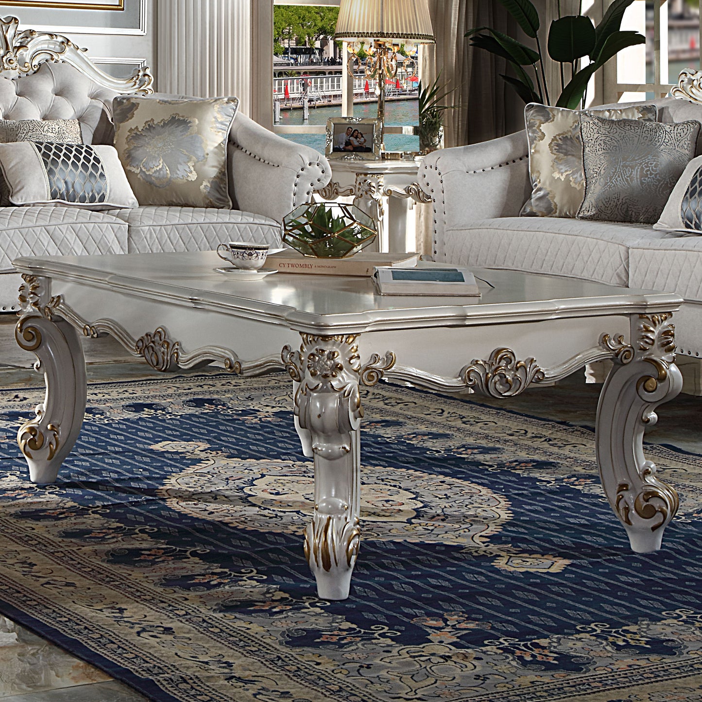 White carved wood coffee table with ornate gold detailing and decorative legs