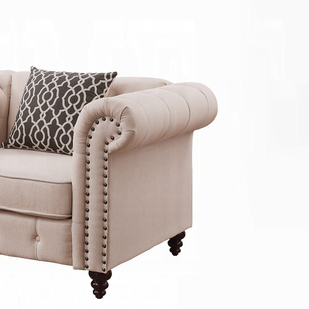 Tufted beige chesterfield sofa arm with decorative nailhead trim