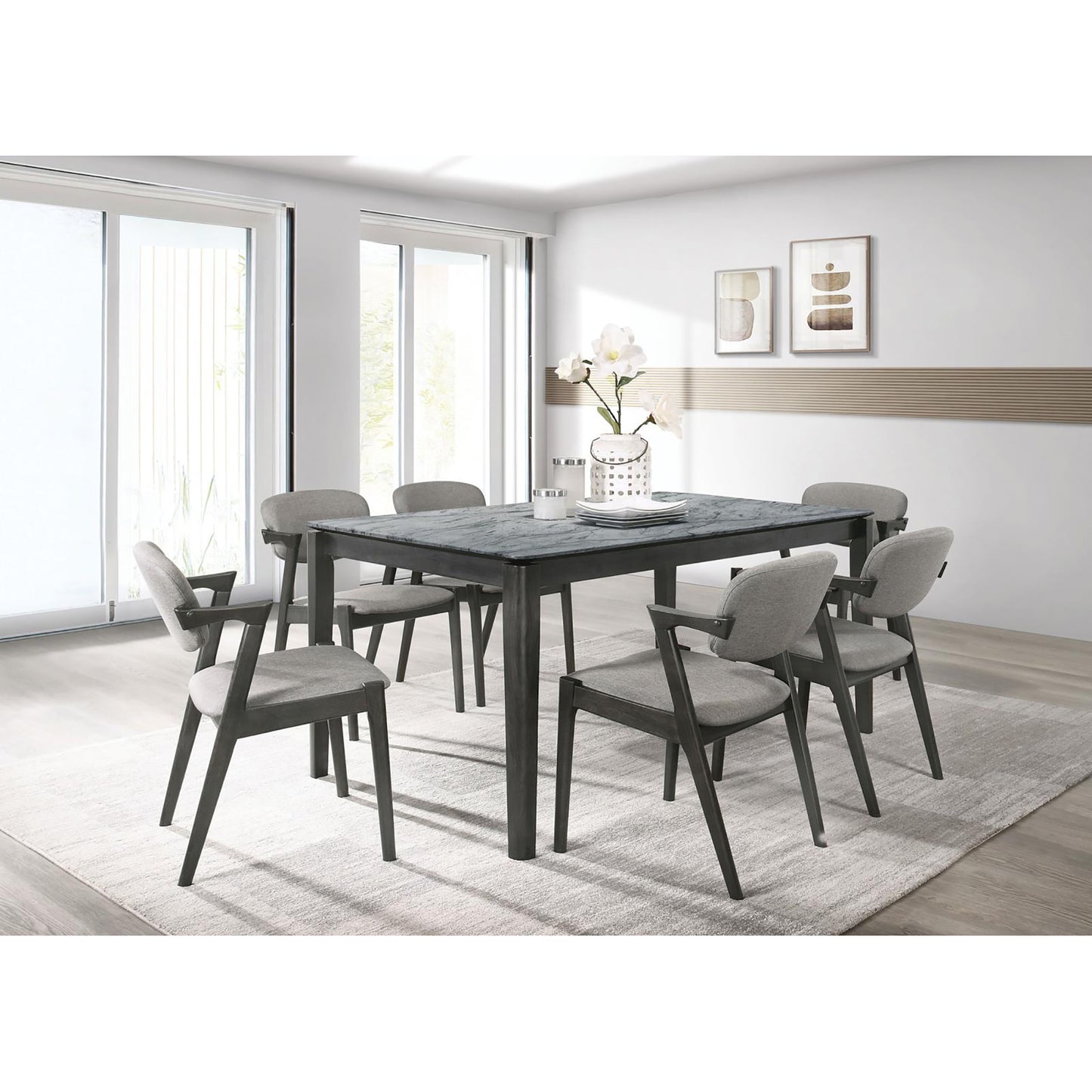 Gray upholstered dining chairs with dark wood frames surrounding a marbletop dining table
