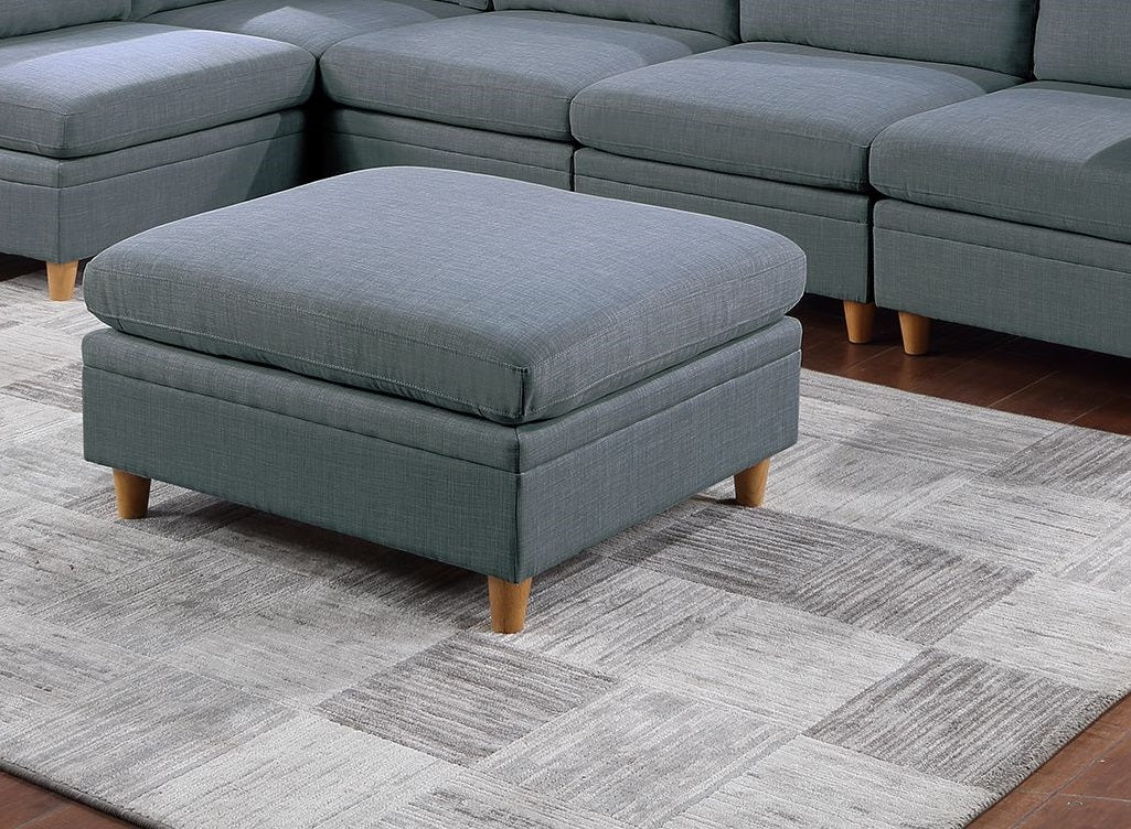 Blue fabric storage ottoman with wooden legs on a patterned rug