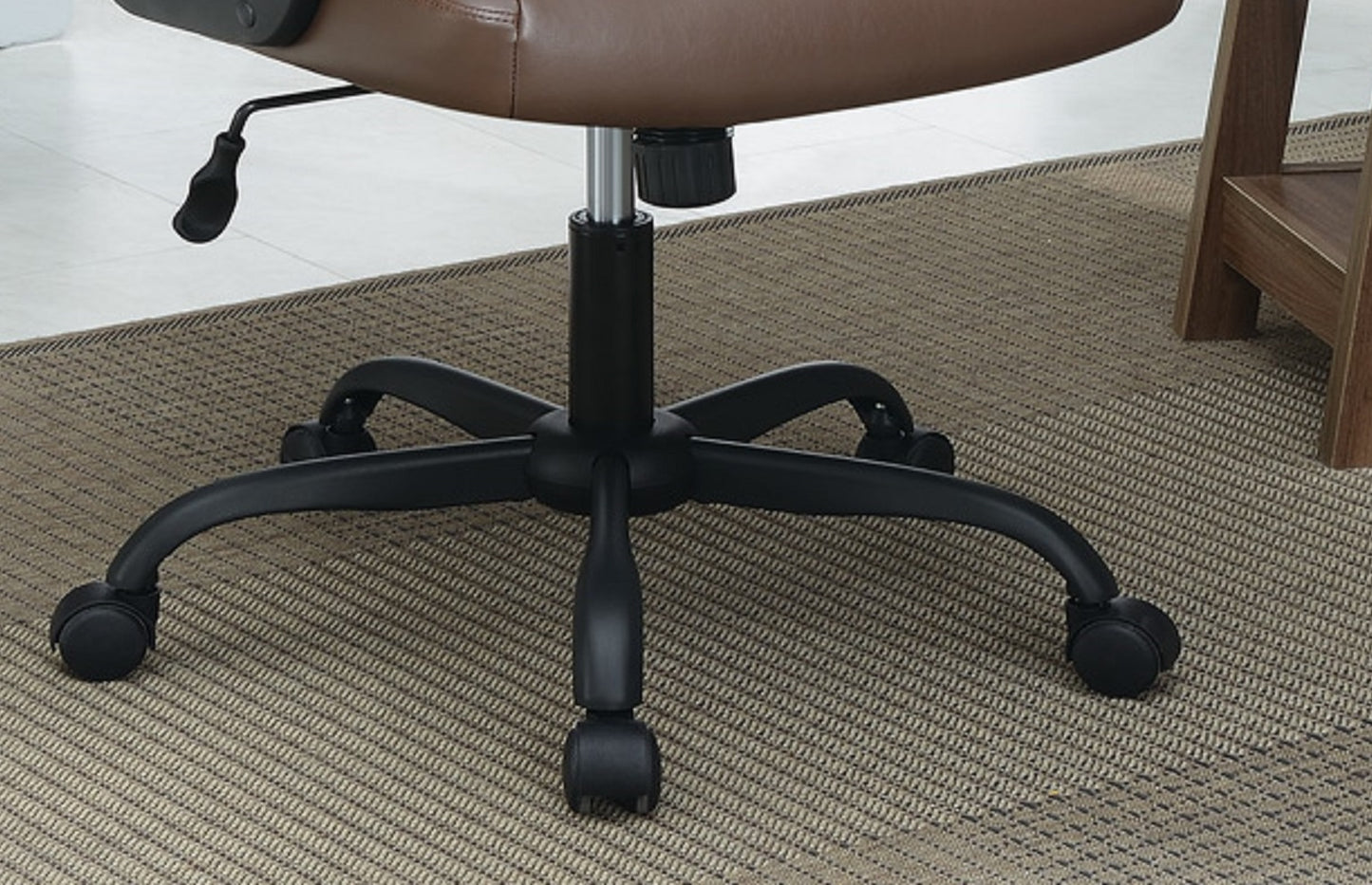 Brown faux leather office chair base with five black casters on a textured rug