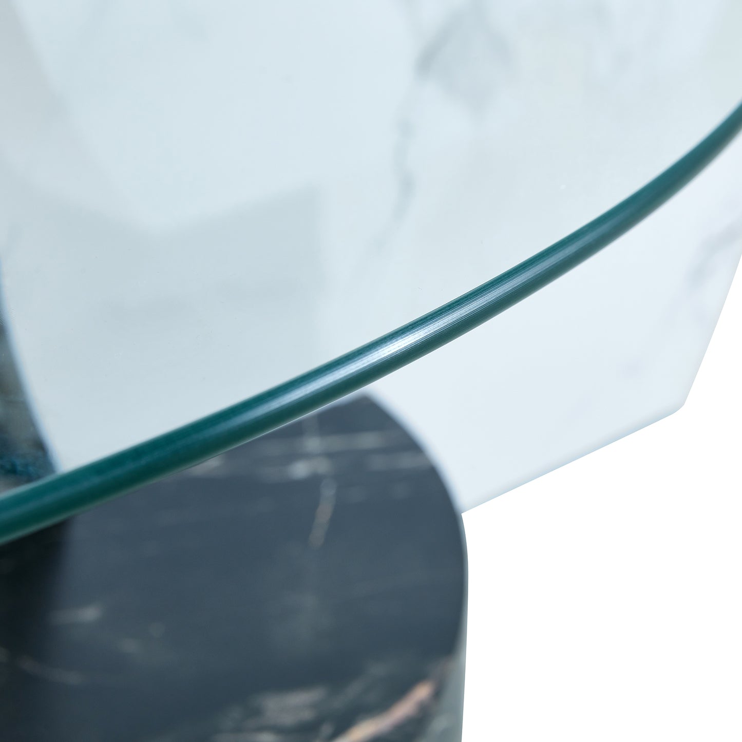 Closeup of a clear glass tabletop with a dark marble base on a modern coffee table