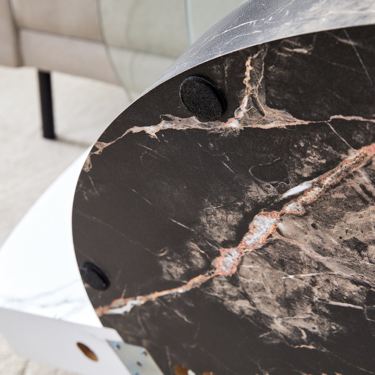 Closeup of round black marble table top with white veining and gold accents