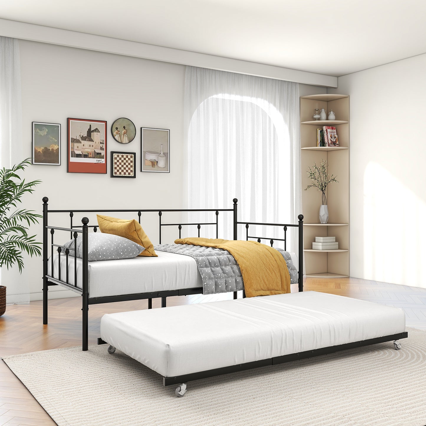 Black metal daybed with pullout trundle featuring ball finials and patterned bedding