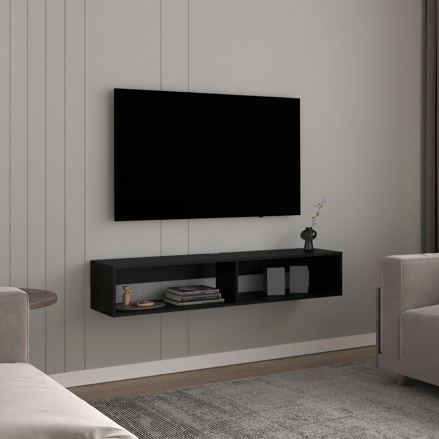 Black floating media console with two open compartments holding books and decorative items