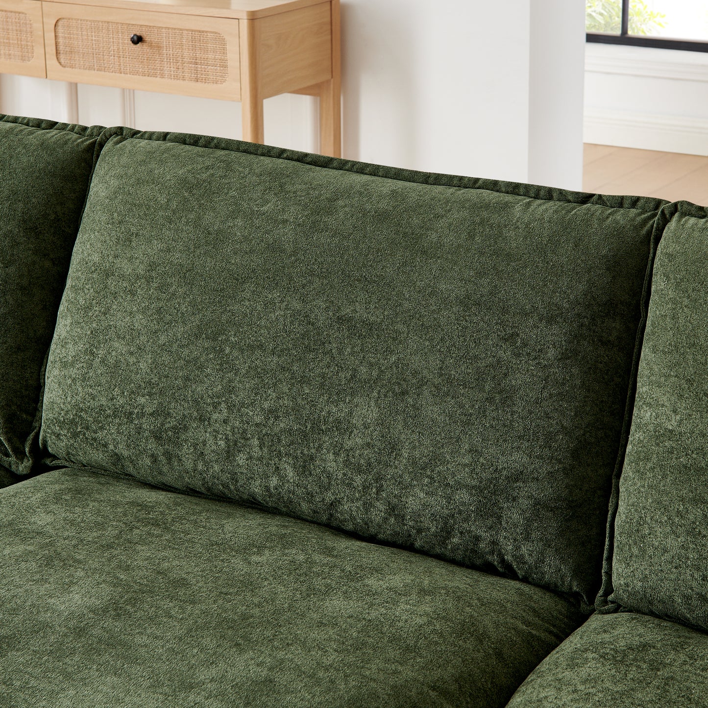 Deep green plush fabric sofa with textured cushions for luxurious comfort