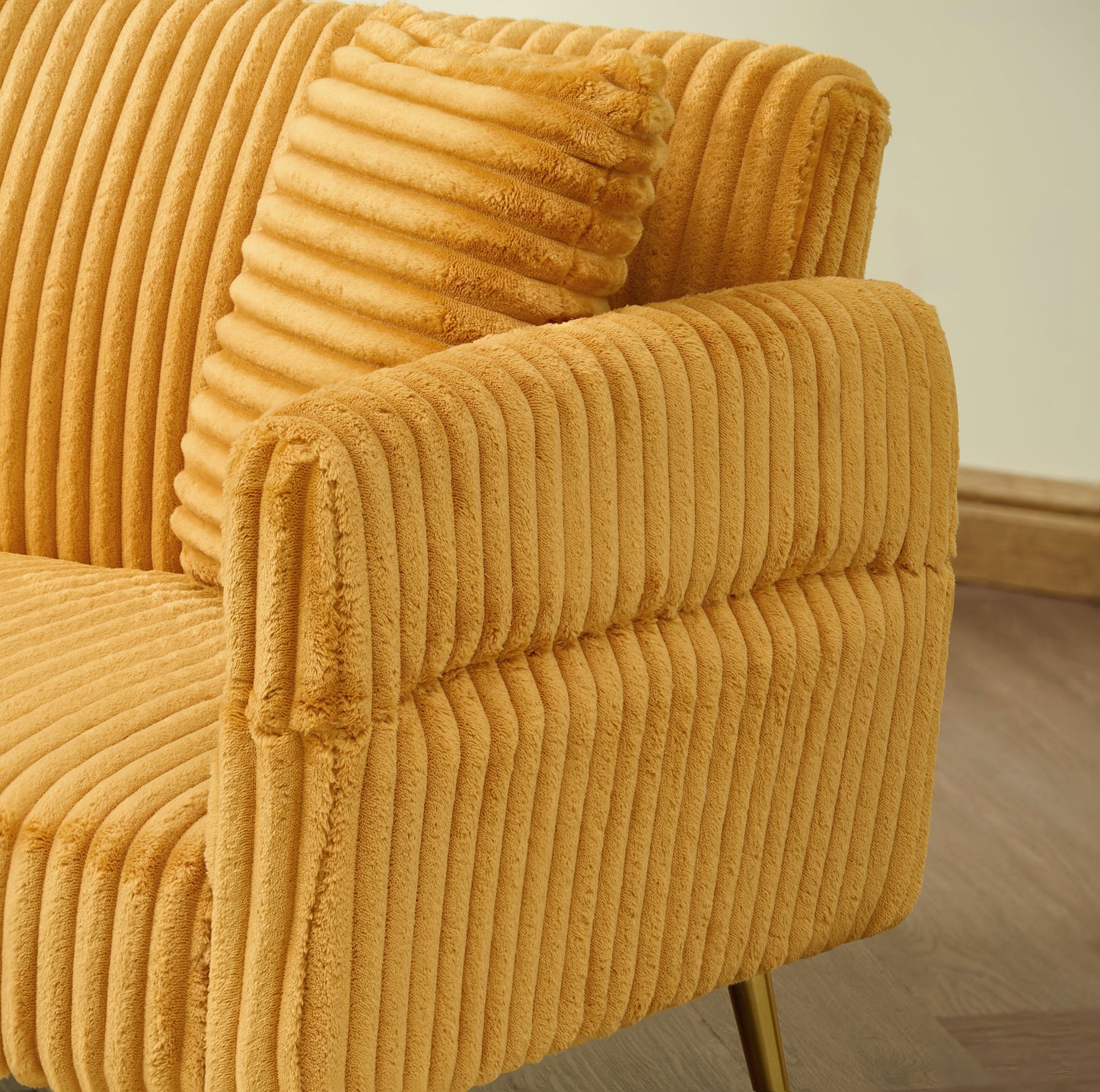 Luxurious mustard yellow corduroy armchair with a plush throw pillow perfect for cozy living rooms
