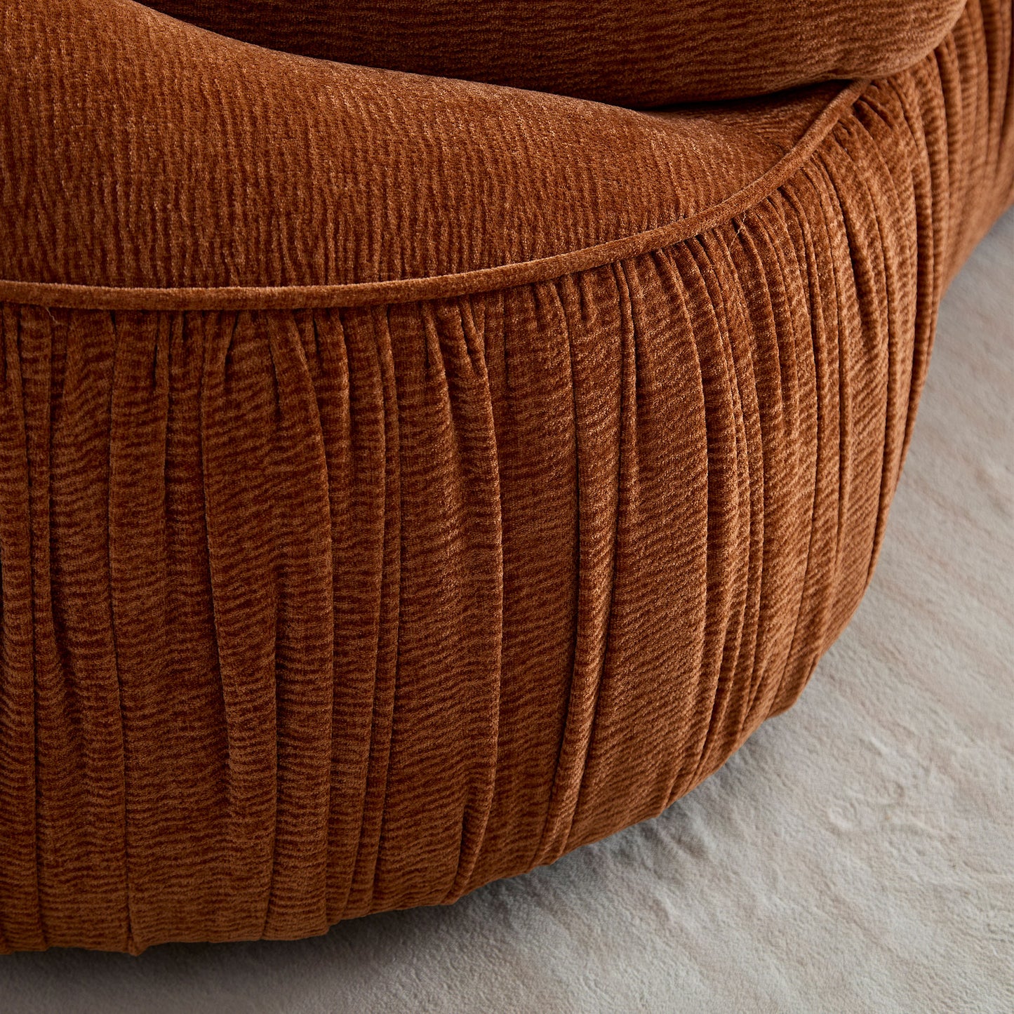 Closeup of rustcolored corduroy fabric texture with vertical pleats on a couch cushion