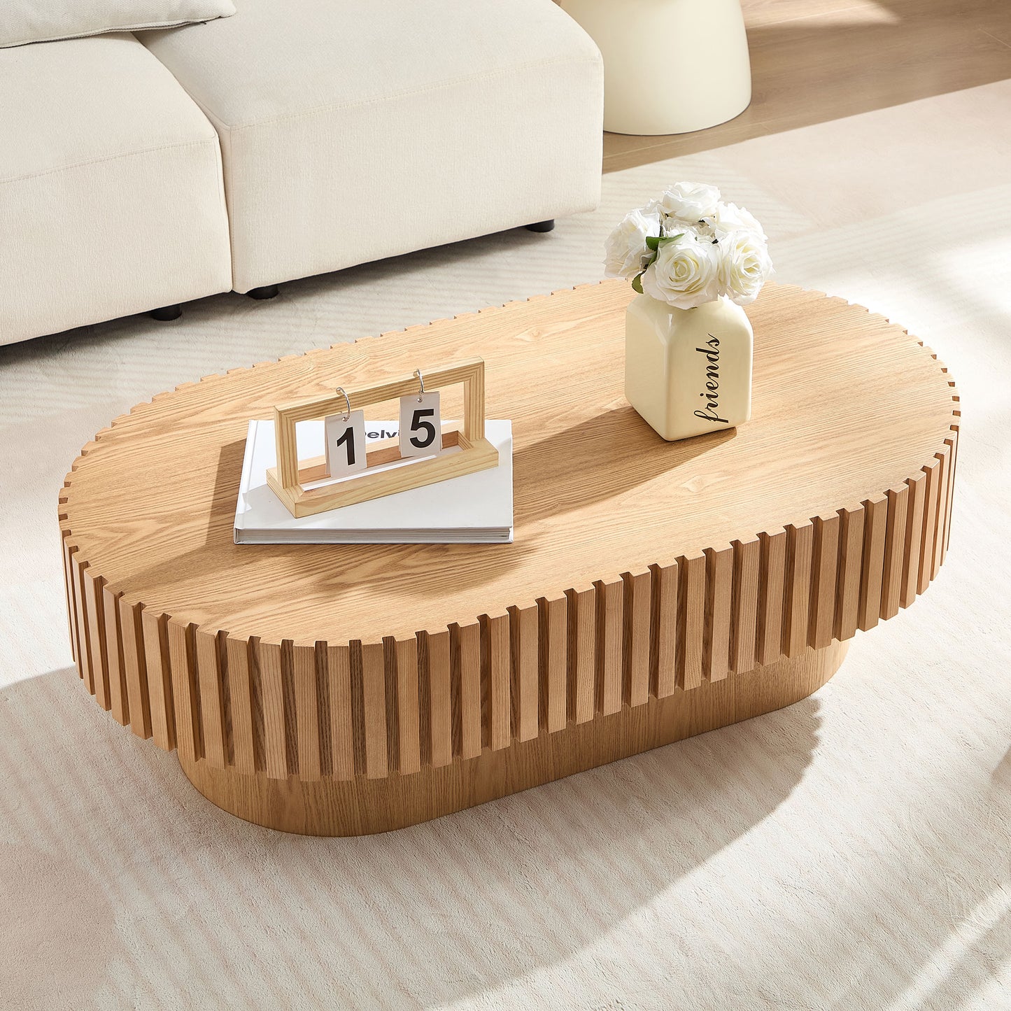 Natural wood oval coffee table with fluted sides and a modern design