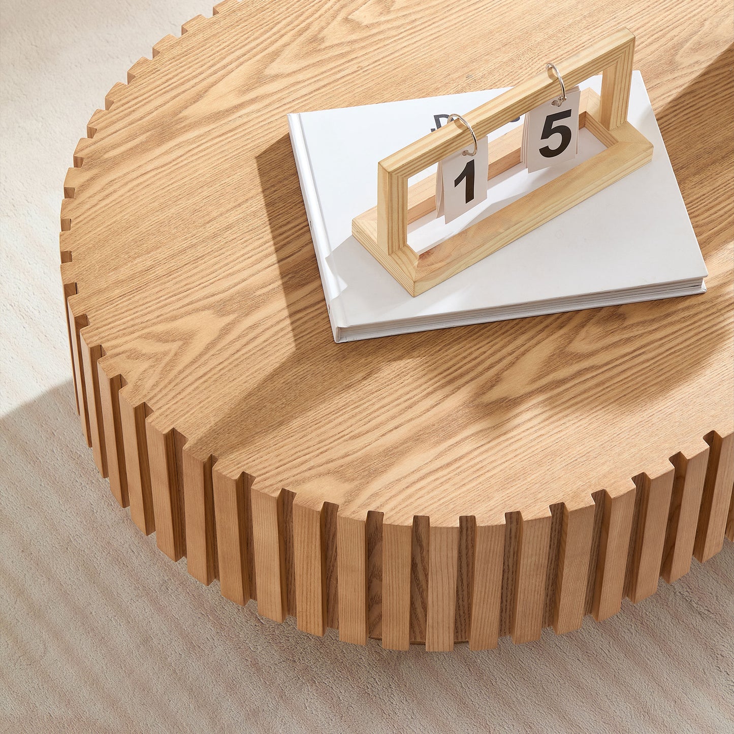 Natural wood round coffee table with fluted base detail characters