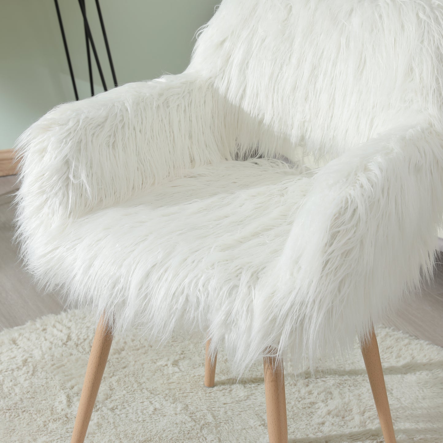 Plush white faux fur armchair with light wood legs perfect for a cozy accent chair