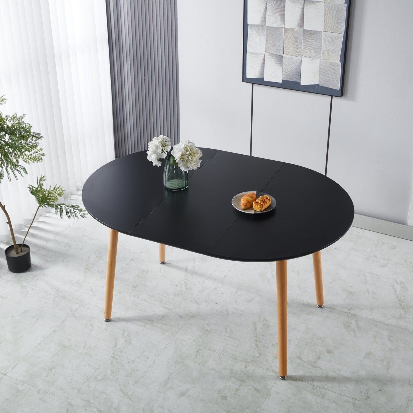 Black oval dining table with natural wood legs perfect for modern kitchens