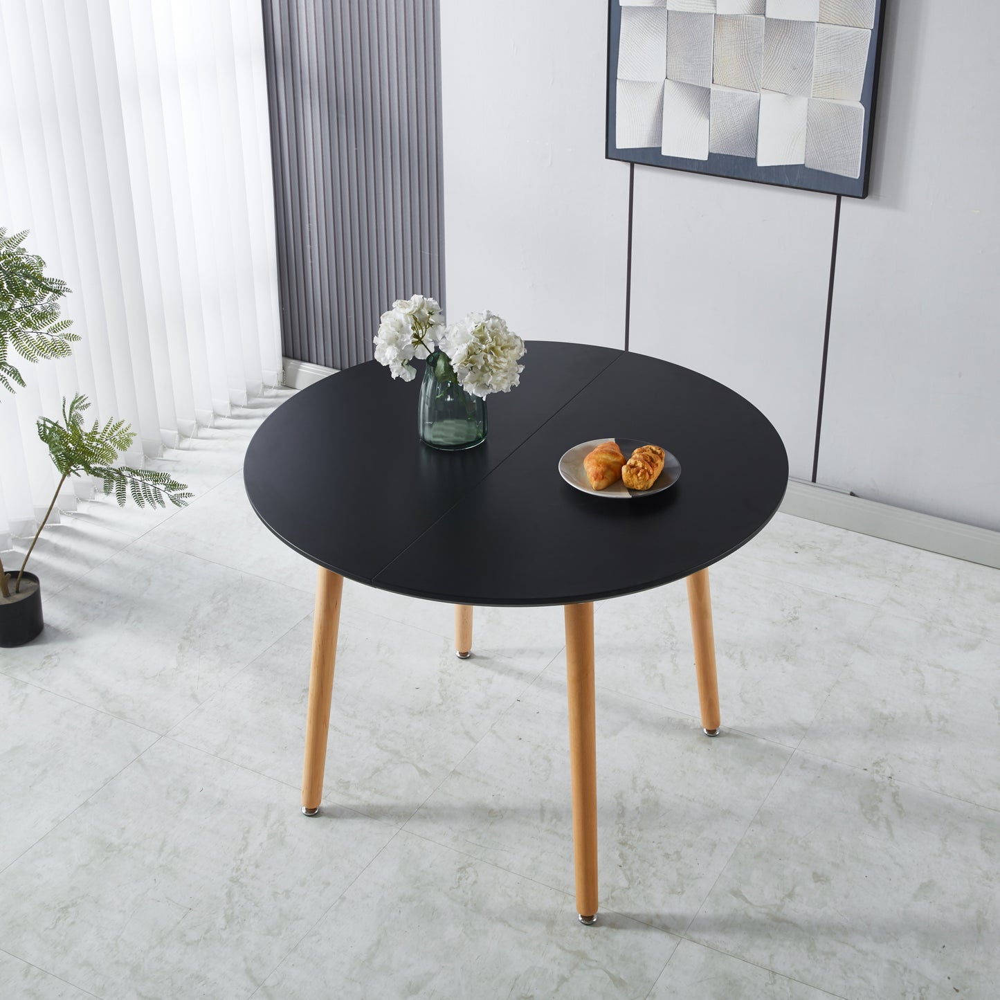 Black round dining table with wooden legs ideal for small spaces