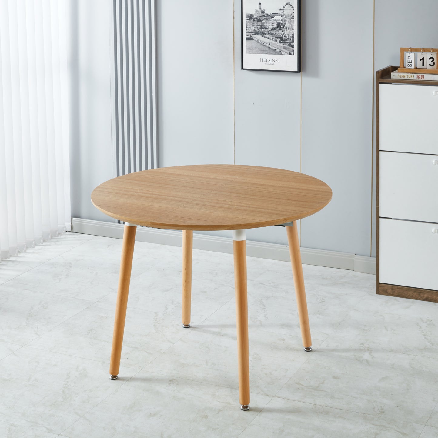 Round light wood dining table with natural grain four tapered legs perfect for compact spaces