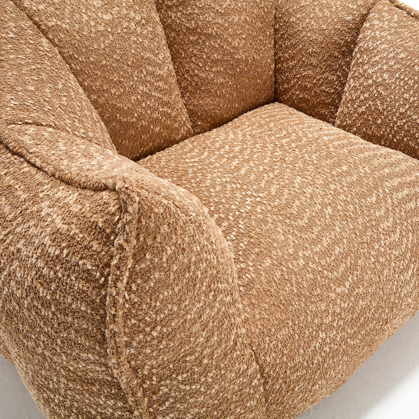 Closeup of a plush textured brown armchair with boucle fabric offering comfort and style