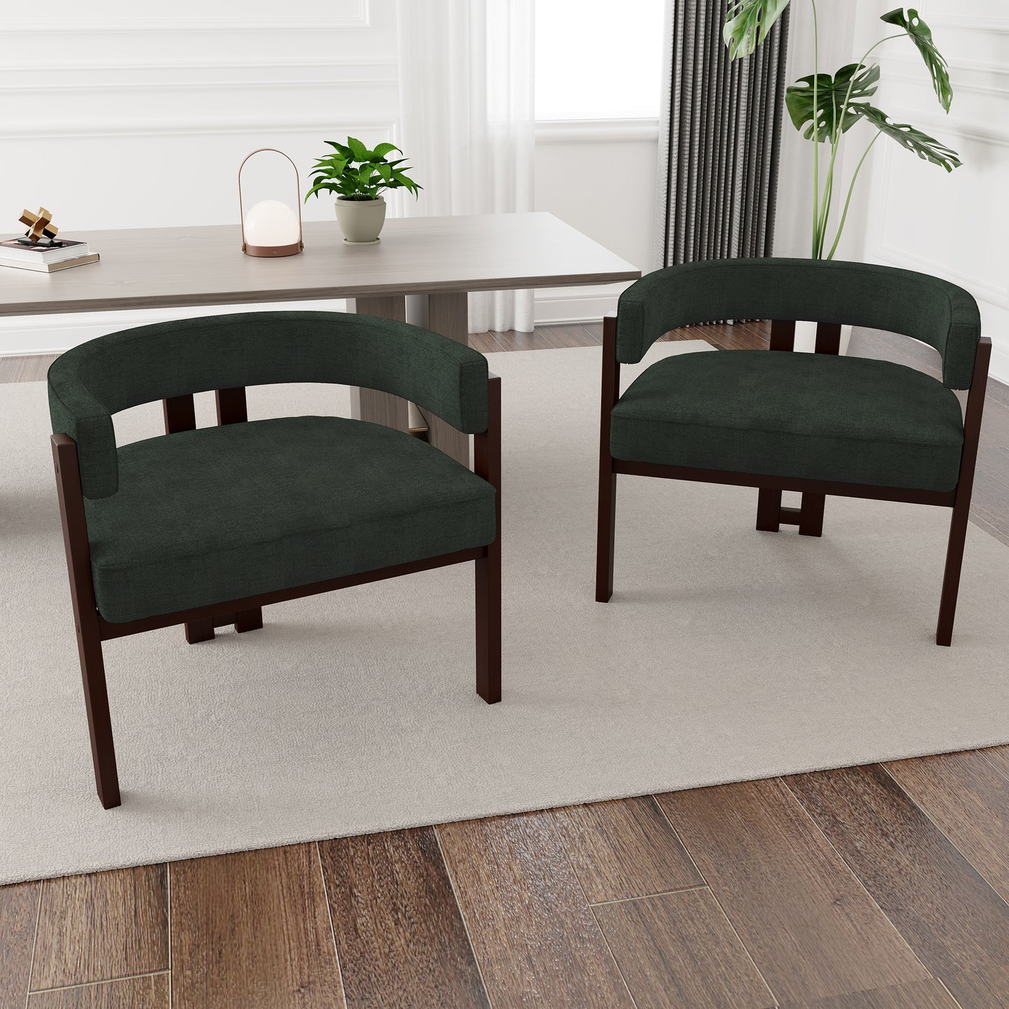 Two dark green fabric armchair chairs with dark wood frames in a dining room setting