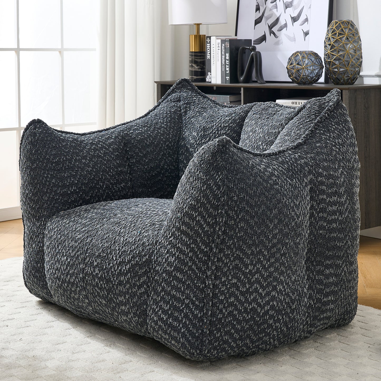 Dark gray textured bean bag chair with wide arms and plush seating