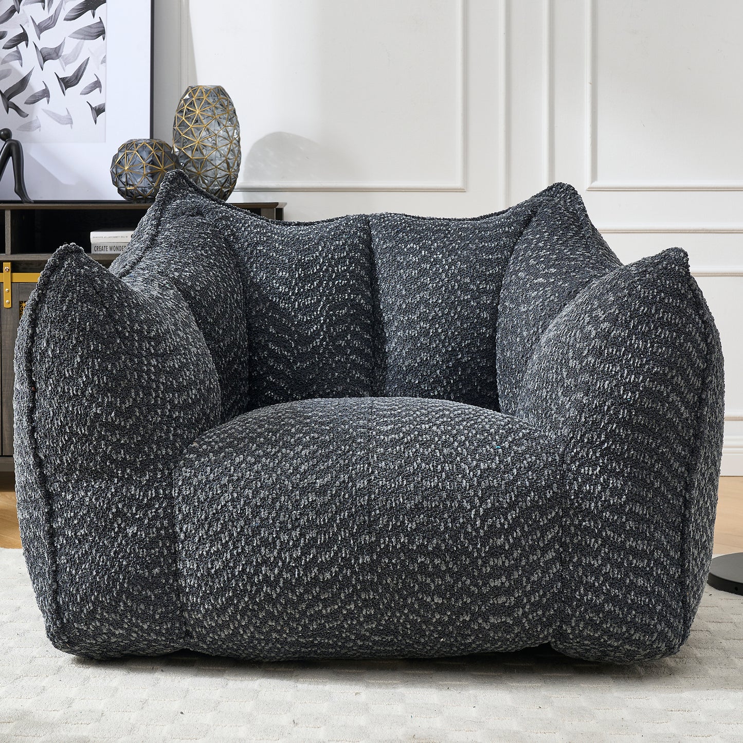 Plush charcoal grey armchair with textured fabric and oversized inviting cushions
